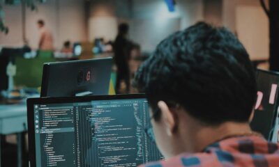Game developer coding on a computer in a workspace