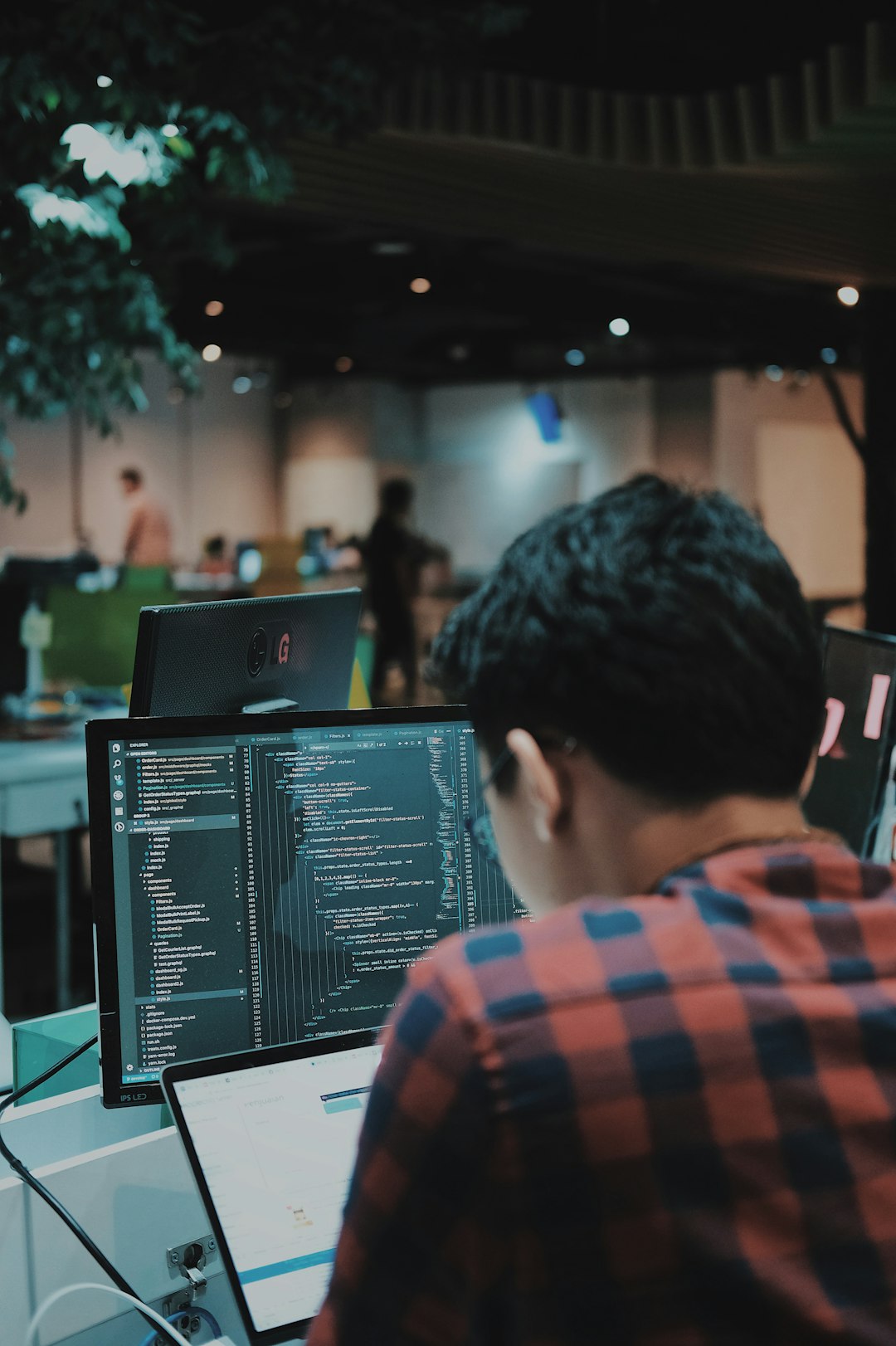 Game developer coding on a computer in a workspace