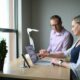IT support professionals working together on a laptop in an office